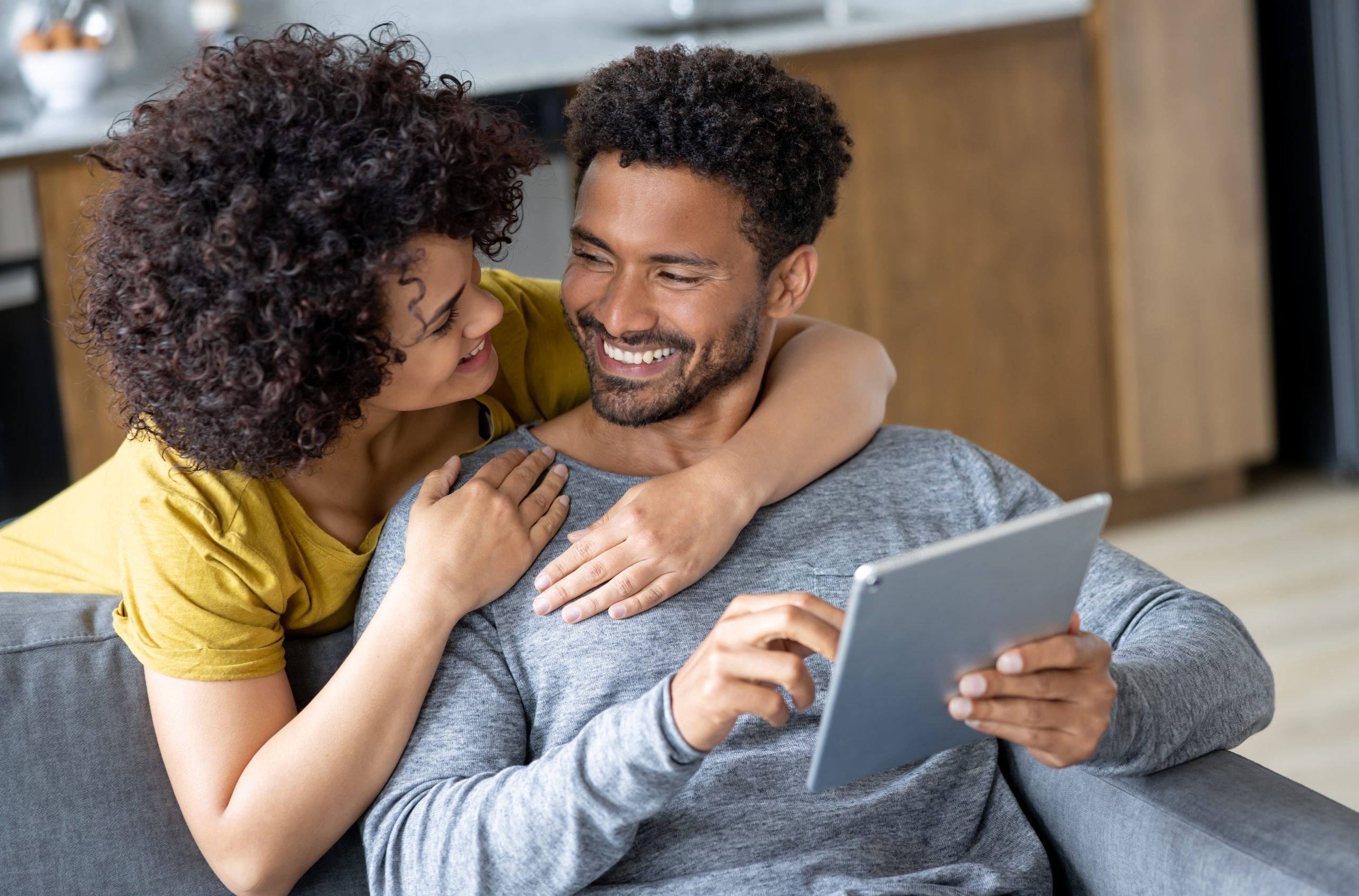 Loving couple at home making a reservation online using their tablet